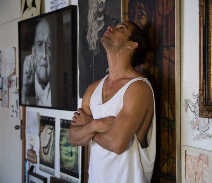 Pablo Morais posa na parede da sala, repleta de quadros (Foto: Thiago Fontolan/Gshow)