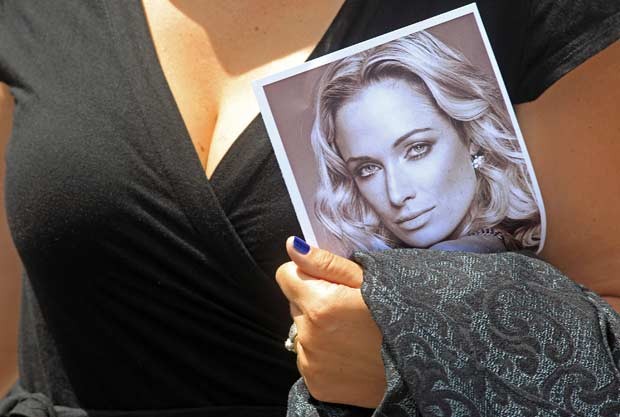 Mulher segura foto de Reeva Steenkamp, namorada de Oscar Pistorius, durante o velório dela em Port Elizabeth, na África do Sul, nesta terça-feira (19) (Foto: AP)