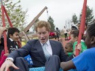 Príncipe Harry brinca em balanço com crianças em Londres