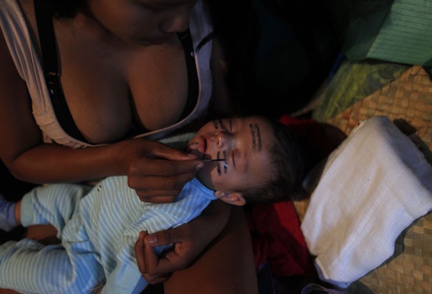 Índia guajajara pinta o rosto de seu filho na Aldeia Maracanã, antigo Museu do Índio (Foto: Pilar Olivares/Reuters)