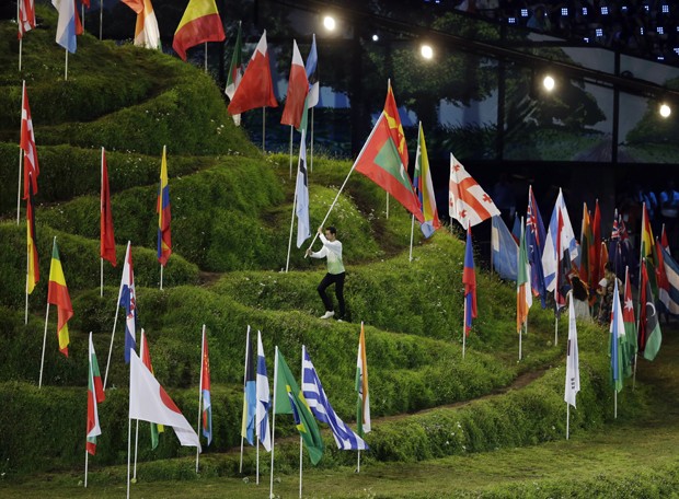 As bandeiras dos mais de 200 países participantes da Olimpíada estão hasteadas no centro do estádio (Foto: AP)