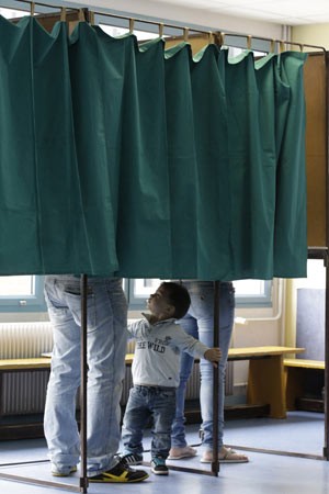 Garoto acompanha os pais na votação em Henin-Beaumont neste domingo (10) (Foto: AFP)