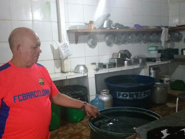 Proprietário de uma peixaria no bairro da Condor, o empresário Manoel Barata, está estocando água para passar pela interrupção de fornecimento de água, em Belém. (Foto: Luana Laboissiere/ G1)