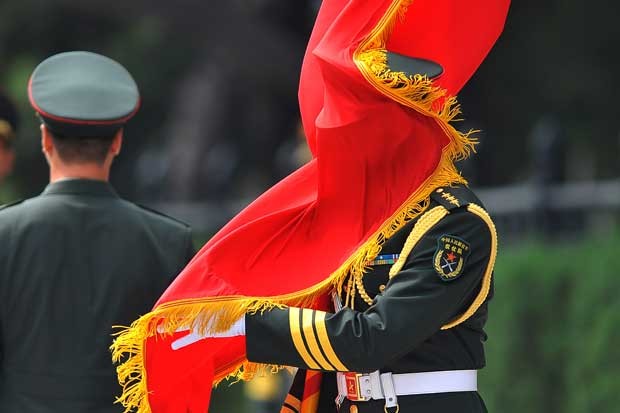 Um soldado chinê é traído pelo vento e  acaba 'se enrolando' com a bandeira vermelha durante sua guada de honra nesta sexta-feira (23). O militar acompanhava a recepção do vice-presidente argentino Amado Boudou pelo vice-presidente chinês Li Yuanchao do lado de fora do Grande Salão em Pequim (Foto: Wang Zhao/ AFP)