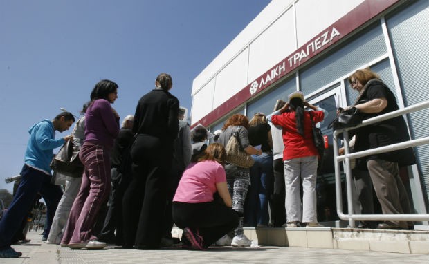 Cipriotas esperam pela abertura de um banco na cidade de Nicosia (Foto: Philippos Christou/AP)