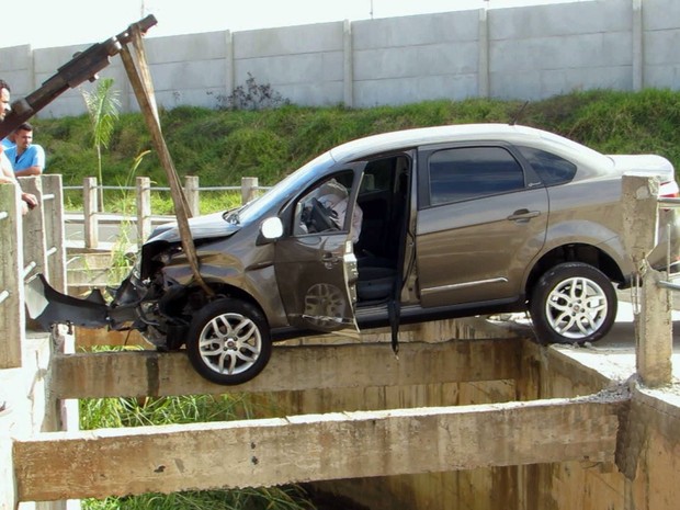 Carro bate em ponte e fica preso em pilastra sobre crrego em Passos (MG). (Foto: Reproduo EPTV)