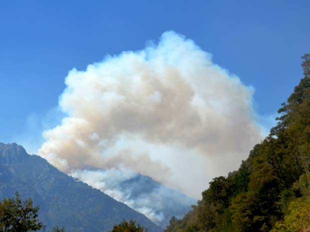 Fumaça provocada por incêndio é vista neste sábado (21) entre as montanhas do parque nacional Conguillo, no Chile (Foto: AFP PHOTO / STR)