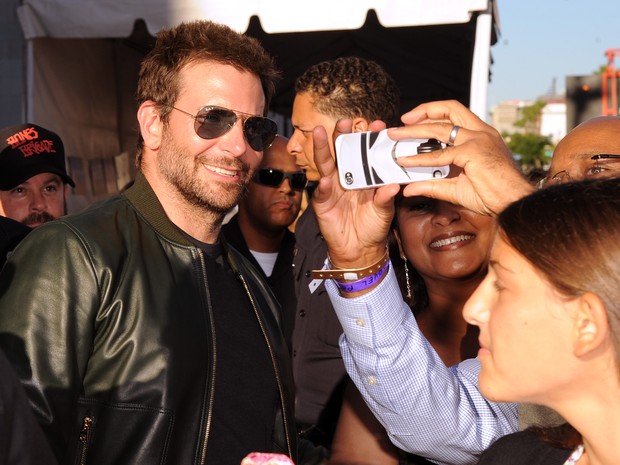 Bradley Cooper posa com fãs em première em Los Angeles, nos Estados Unidos (Foto: Kevin Winter/ Getty Images/ AFP)