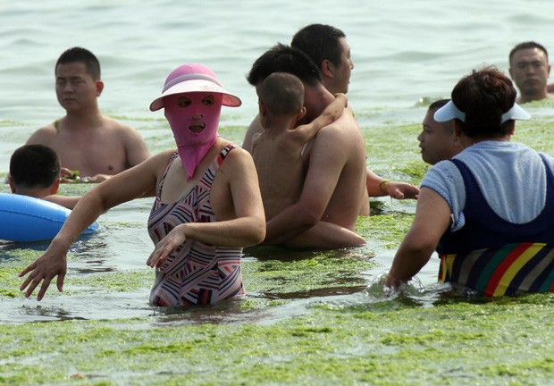 Traje de banho bizarro é uma das alternativas para s chineses protegerem o rosto contra queimaduras e águas-vivas (Foto: AFP)