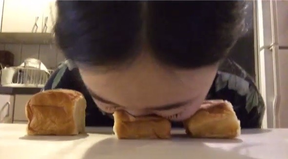Mulher esfrega o rosto em pães
