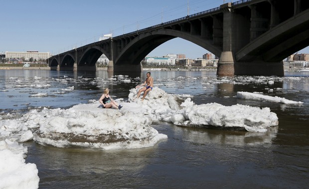 Russos tomam banho de sol deitados sobre blocos de gelo na Sibéria (Foto: Ilya Naymushin/Reuters)