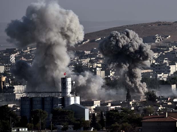 Fumaça emerge da cidade síria de Kobane, após bombardeio da coalizão internacional liderada pelos Estados Unidos, nesta sexta-feira (10) (Foto: AFP PHOTO / ARIS MESSINIS)