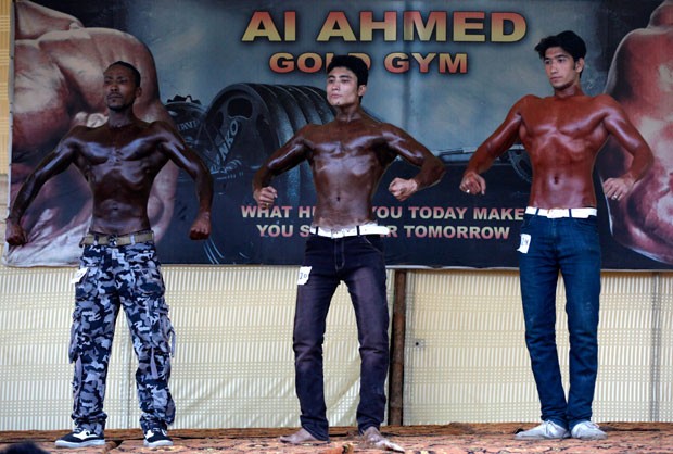 Três atletas exageram na pintura para divulgar campeonato de fisiculturismo no Paquistão (Foto: Akhtar Soomro/Reuters) Três atletas exageram na pintura para divulgar campeonato de fisiculturismo no Paquistão (Foto: Akhtar Soomro/Reuters)