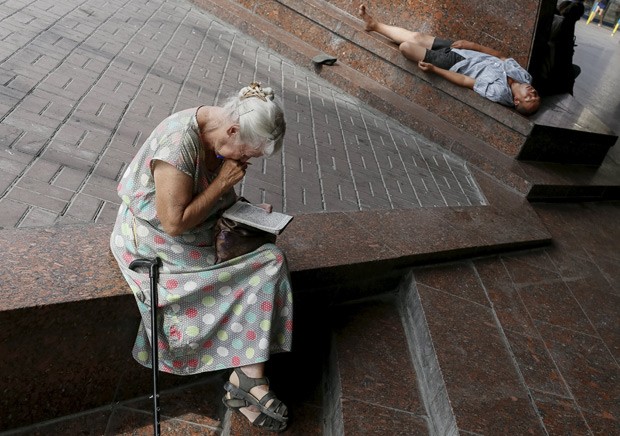  Mulher idosa faz palavras cruzadas em uma praça de Kiev, na Ucrânia, em foto de 20 de julho: segundo pesquisas, mulheres com falhas cognitivas leves sucumbem à demência mais rapidamente do que homens (Foto:  Reuters/Gleb Garanich  )