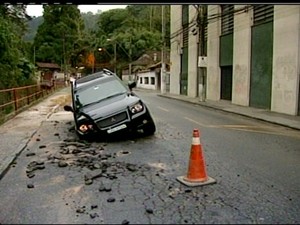 Parte do carro foi engolida pelo buraco (Foto: Reprodução / Inter TV)