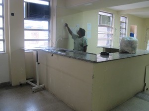 Técnica de enfermagem recolhe material de UTI desativada do Iaserj (Foto: Alba Valéria Mendonça/ G1)