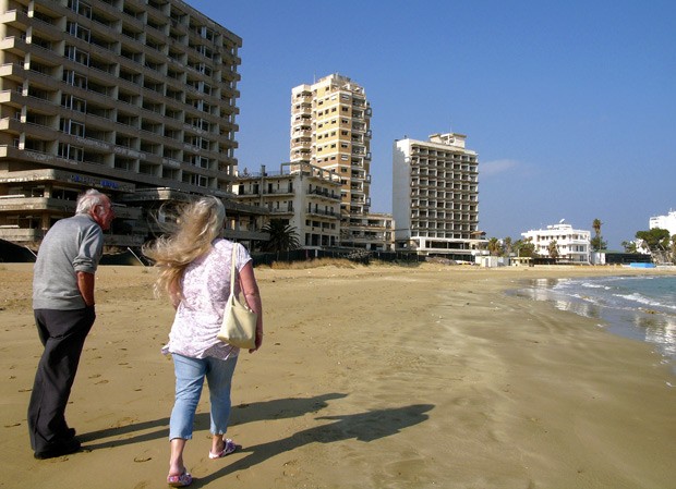 Casal caminha pela praia deserta em Varosha em 17 de janeiro (Foto: AP Photo/Petros Karadjias)