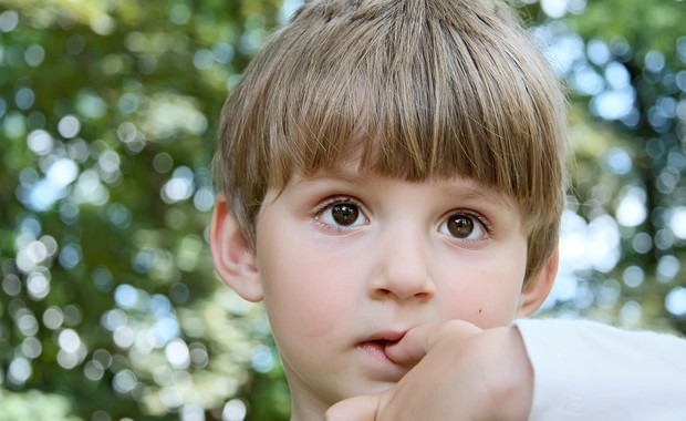 Criança preocupada com o dedo na boca (Foto: Shutterstock)