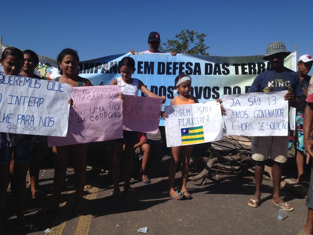 Manifestantes usaram faixas para pedir regularização das terras (Foto: Gilcilene Araújo/G1)
