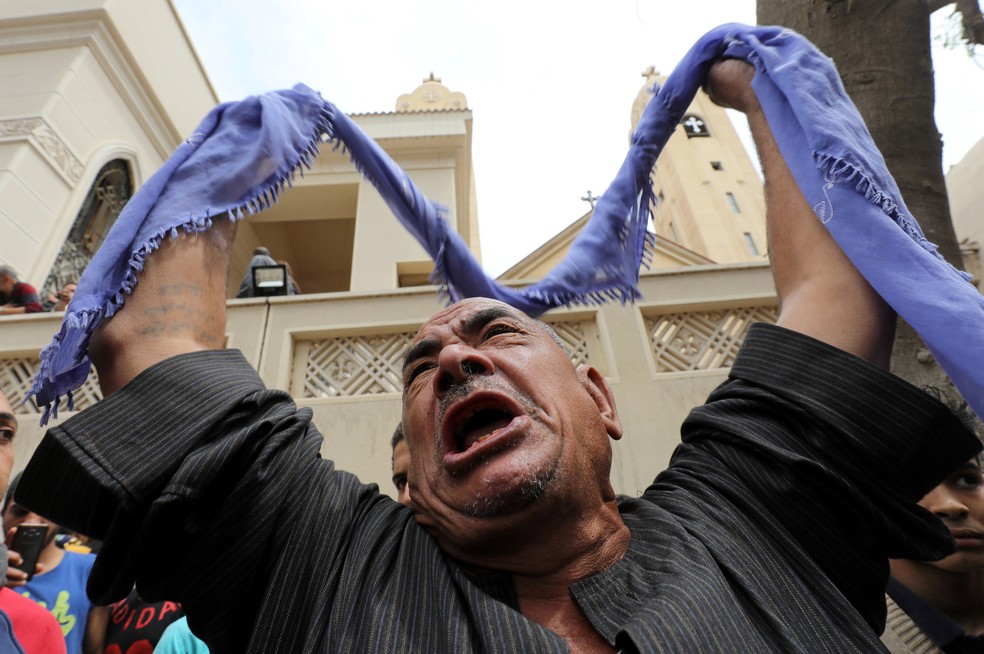 Familiar de vítima em frente a igreja alvo de ataque em Tanta, no Egito, neste domingo (9) (Foto: Mohamed Abd El Ghany/Reuters)
