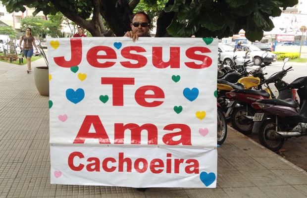 Homem faz cartaz com mensagem de otimismo para Carlinhos Cachoeira, em Goiânia (Foto: Carolina Simiema/G1)