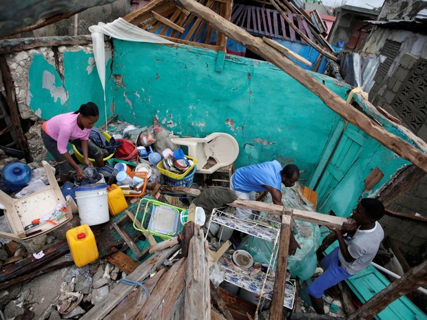 Moradores limpam casa destruída por passagem do furacão Matthew em Les Cayes, no Haiti, na quarta (5) (Foto: Reuters/Andres Martinez Casar)