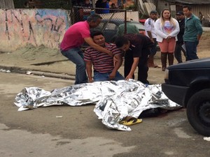 Homem chora ao ver corpo de baleado na tarde desta quarta-feira (8) na rua Gumercindo Coelho em Mogi das Cruzes (Foto: Luis Corvini/ TV Diário)