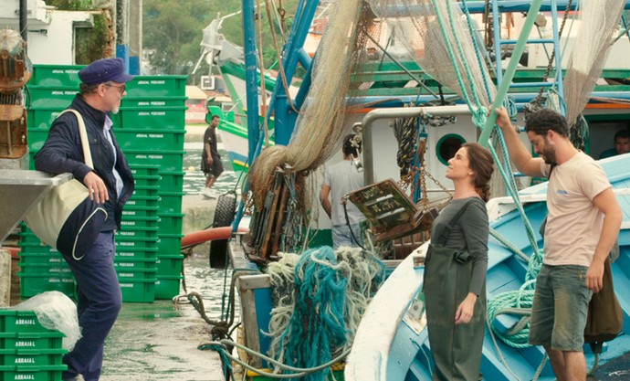 Animada, Alice se despede de Patrick ao entrar no barco com pescadores (Foto: TV Globo)