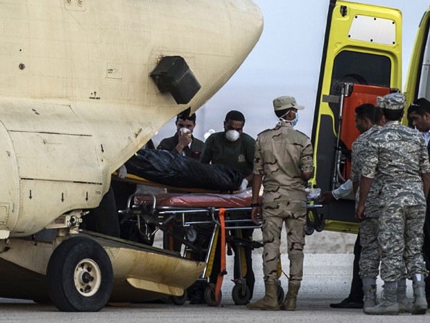Paramédicos egípcios transportam corpos das vítimas da queda do avião russo em aeronave militar.   (Foto: AFP PHOTO / KHALED DESOUKI )