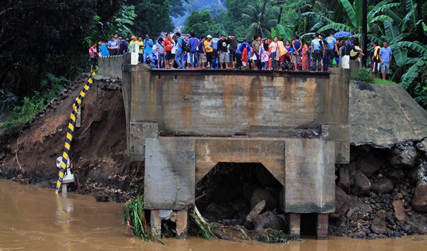Moradores observam ponte que se rompeu após fortes chuvas nas Filipinas. (Foto: Erwin Mascarinas/AFP)
