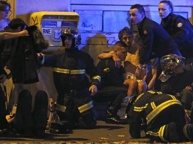 Homem é socorrido após tiroteio perto do Bataclan, conhecida sala de espetáculos de Paris, na França (Foto: Christian Hartmann/Reuters) Homem é socorrido após tiroteio perto do Bataclan, conhecida sala de espetáculos de Paris, na França (Foto: Christian Hartmann/Reuters)