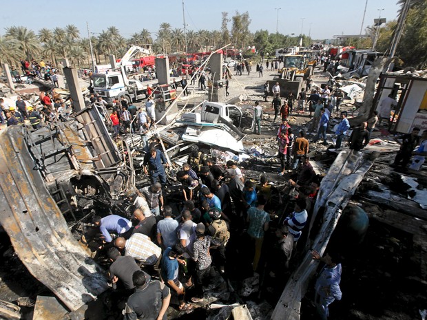  Moradores se reúnem no local do atentado na cidade de Hilla, no Iraque,  neste domingo (6) (Foto: Reuters/Alaa Al-Marjani)