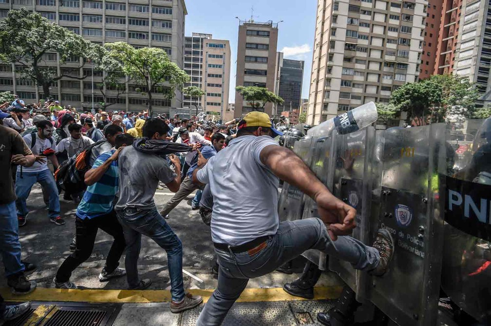 Manifestantes de oposição ao governo Maduro entram em confronto com policiais em Caracas  (Foto: Juan Barreto / AFP)