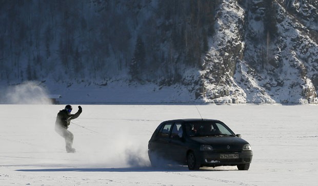 Russo praticou snowboarding puxado por carro na superfície congelada do rio Yenisei (Foto: Ilya Naymushin/Reuters)