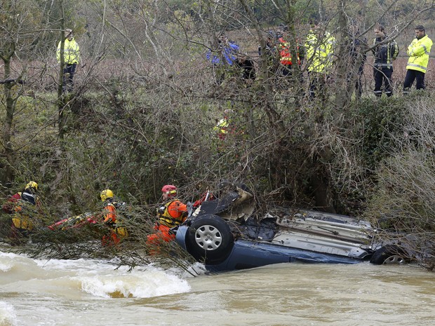 Equipe de resgate tenta virar carro que foi arrastado pelas águas em um rio que transbordou perto de Cruviers-Lascours, na França. Uma mulher e seus dois filhos morreram no acidente (Foto: AFP Photo/Boris Horvat)
