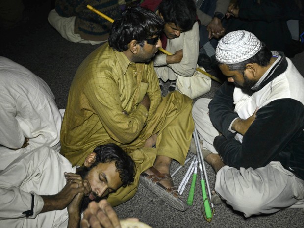 Manifestantes cegos sentam na rua durante manifestação por empregos em Lahore, no Paquistão (Foto: AFP Photo/Arif Ali) Manifestantes cegos sentam na rua durante manifestação por empregos em Lahore, no Paquistão (Foto: AFP Photo/Arif Ali)