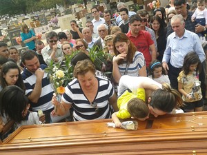  A viúva e um dos filhos junto ao caixão instantes antes do piloto ser enterrado (Foto: Erick Gimenes)