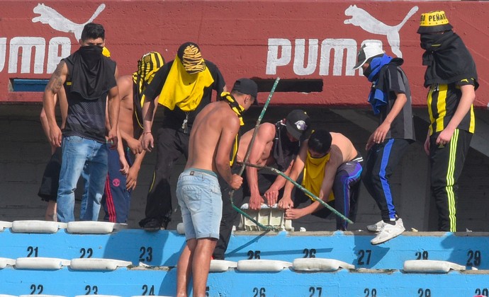 Torcedores de Peñarol e Nacional arrancam assentos do estádio Centenário (Foto: Miguel Rojo/AFP)