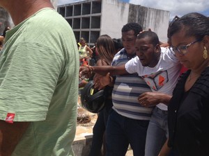 Marido se despera em sepultamento da mulher em Camaçari (Foto: Juliana Almirante / G1)