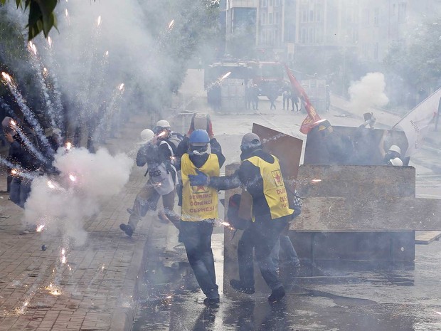 Fogos de artifícios explodem perto de manifestantes durante protesto em Istambul, na Turquia. (Foto: Umit Bektas / Reuters)