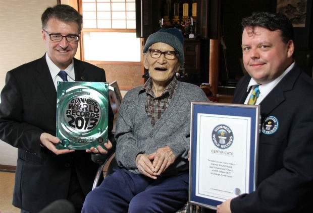 O japonês Jiroemon Kimura, de 115 anos, recebe da equipe do Guinness um certificado. Ele é considerado a pessoa mais velha do mundo pela entidade (Foto: Kyotango City/AP)