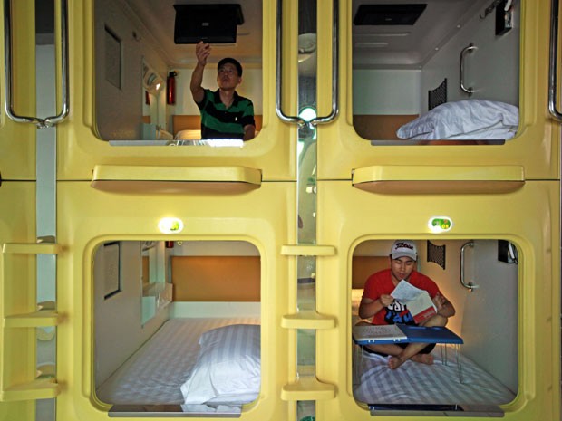Hóspedes em suas cápsulas no hotel chinês (Foto: AFP)