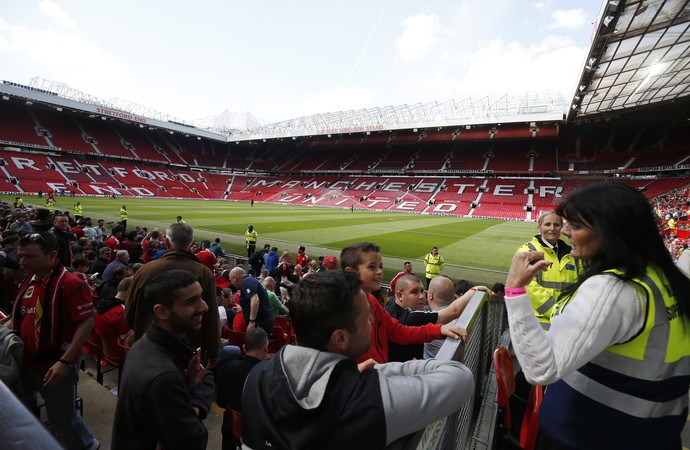 Segurança dá orientações a torcedores no Old Trafford antes do jogo do Manchester United (Foto: Reuters / Andrew Yates)
