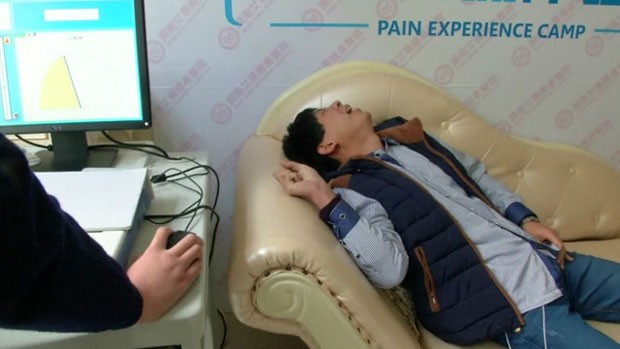 Simulador usa uma corrente elétrica para estimular a pele dos homens e reproduzir em parte o que mulheres sentem antes de dar à luz na China (Foto: Reuters)