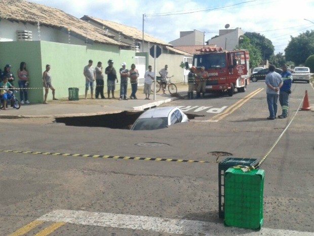 Carro foi engolido após asfalto ceder e cratera se abrir (Foto: Flávia Galdiole/ TV Morena)