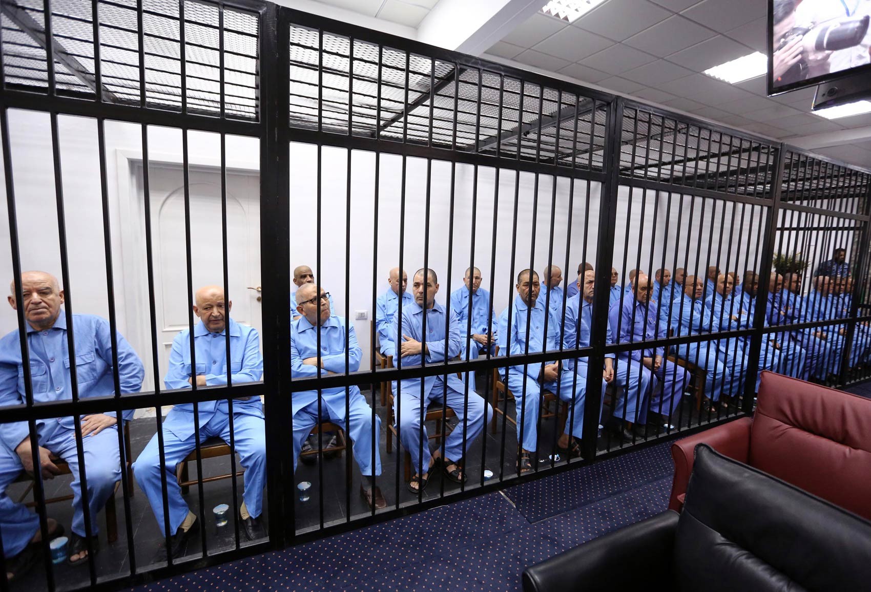 Antigos colaboradores do ditador deposto Muammar Kadhafi são mantidos atrás das grades dos acusados durante julgamento em Trípoli, Líbia. O tribunal condenou à morte Seif al Islam Kadhafi, o filho mais conhecido do ex-ditador, além de 8 dos colaboradores (Foto: Mahmud Turkia/AFP) Antigos colaboradores do ditador deposto Muammar Kadhafi são mantidos atrás das grades dos acusados durante julgamento em Trípoli, Líbia. O tribunal condenou à morte Seif al Islam Kadhafi, o filho mais conhecido do ex-ditador, além de 8 dos colaboradores (Foto: Mahmud Turkia/AFP)