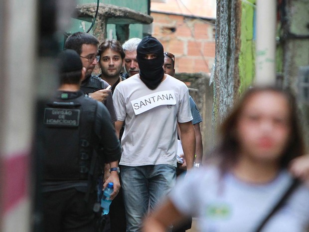 Encapuzado, agente da Polcia Civil participa da reconstituio de assassinatos no Complexo do Alemo: o do menino Eduardo de Jesus, da dona de casa Elizabeth de Moura Francisco e do capito da PM Uanderson Manoel da Silva, na Zona norte do Rio (Foto: Carlos Moraes/Agncia O Dia/Estado Contedo)