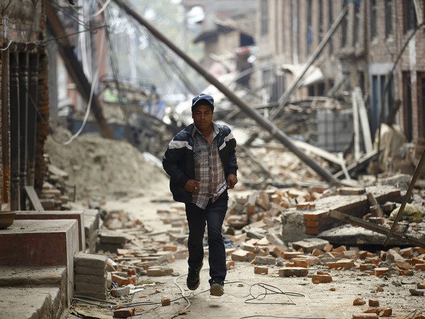 26/04 - Homem corre entre ruínas de prédios em Bhaktapur, após segundo tremor no domingo (Foto: Navesh Chitrakar / Reuters) 26/04 - Homem corre entre ruínas de prédios em Bhaktapur, após segundo tremor no domingo (Foto: Navesh Chitrakar / Reuters)