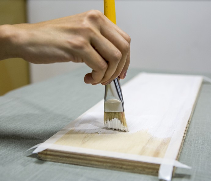 Passe uma fita adesiva na borda e cubra a madeira com um primer (Foto: Ellen Soares/Gshow)