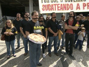 Usando mordaças, policiais federais distribuem pizza em protesto na capital mineira (Foto: Reprodução/TV Globo)